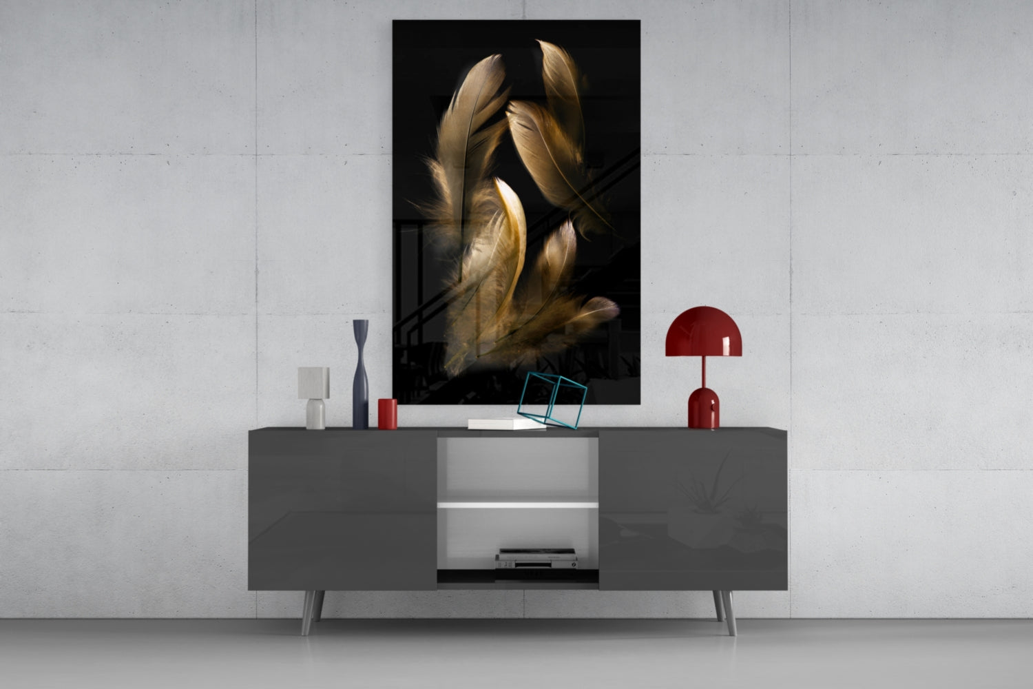 Tan feather glass wall art displayed above gray modern console table with red lamp and decorative objects against white brick wall.
