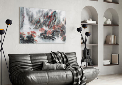 Japanese landscape glass wall art with red foliage and misty mountains displayed above black leather sofa in modern living room.