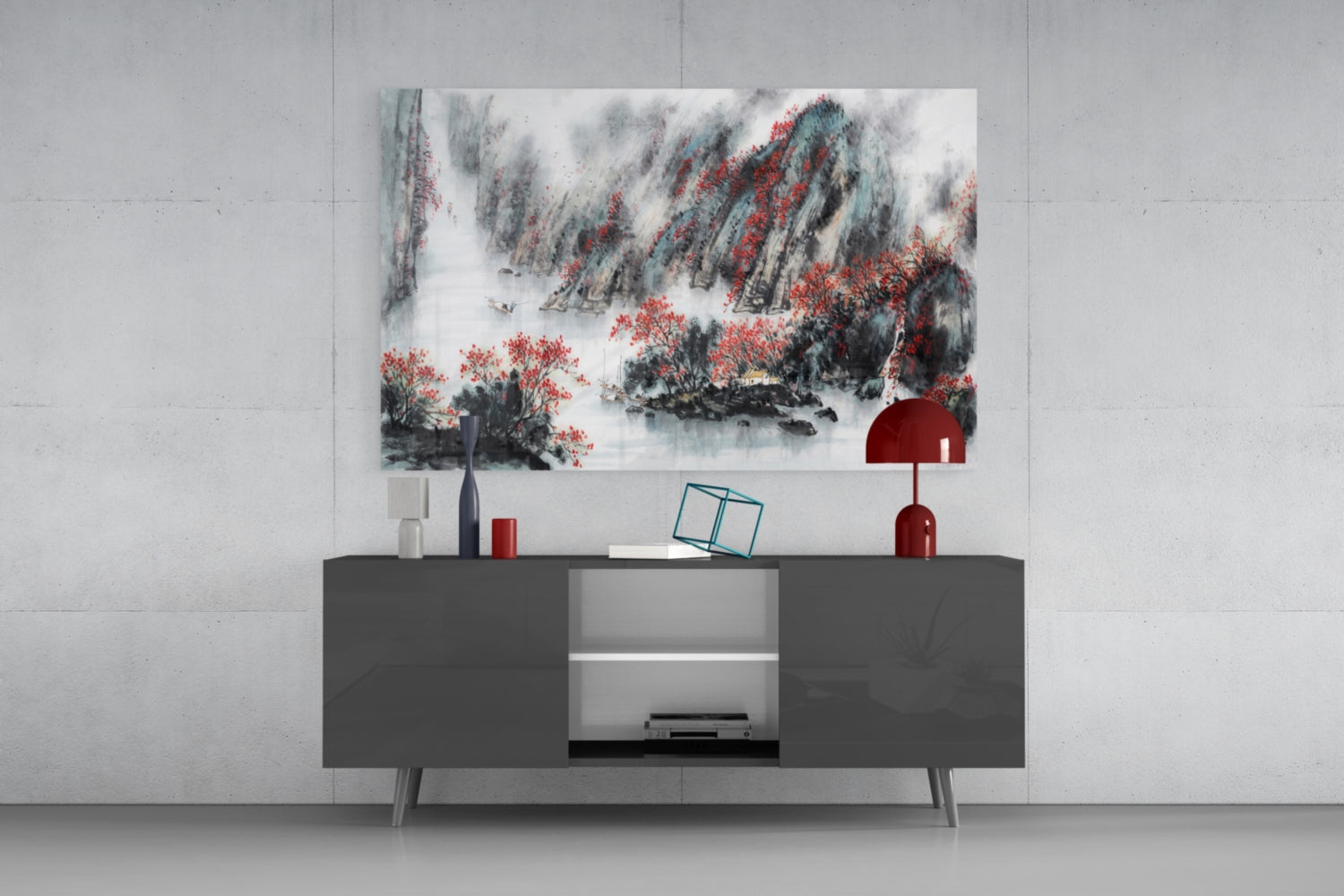 Japanese landscape glass wall art featuring red flowering trees and misty mountains displayed above a dark gray media console with decorative accessories.