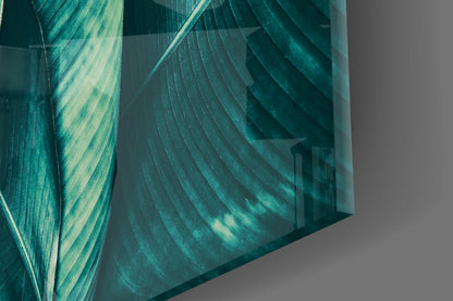 Close-up angled view of layered teal and pale green striped glass panels casting shadows on gray surface.