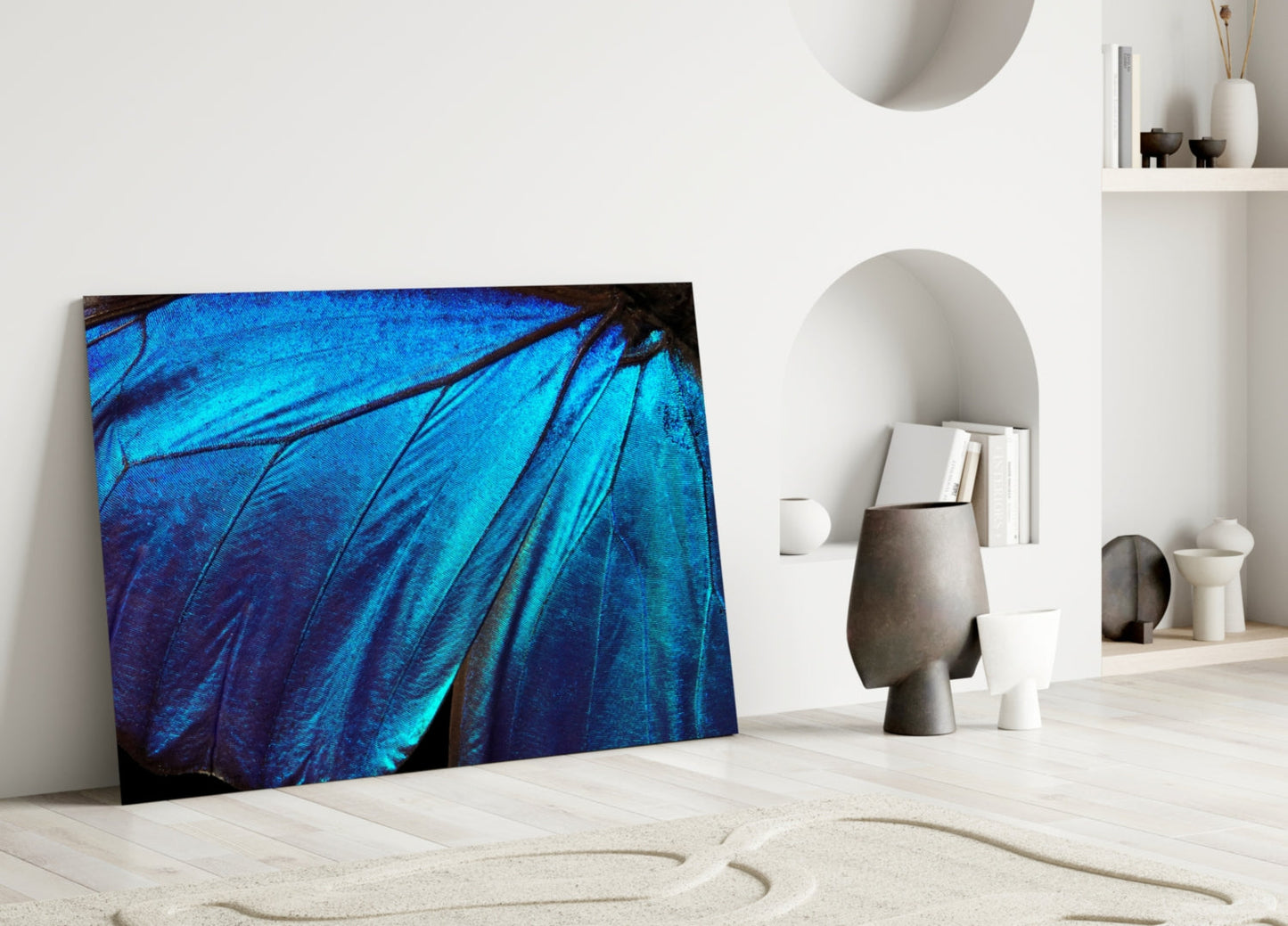 Iridescent blue butterfly wing glass art leaning against white wall in minimalist interior setting.