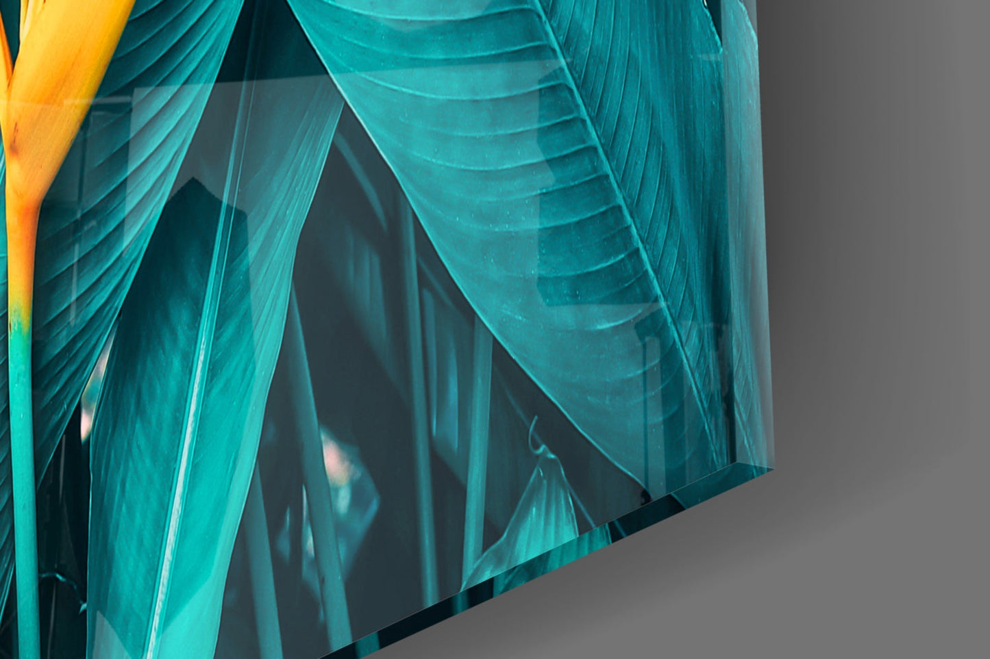 Close-up detail of layered turquoise glass leaves with yellow accent and visible texture against neutral background.