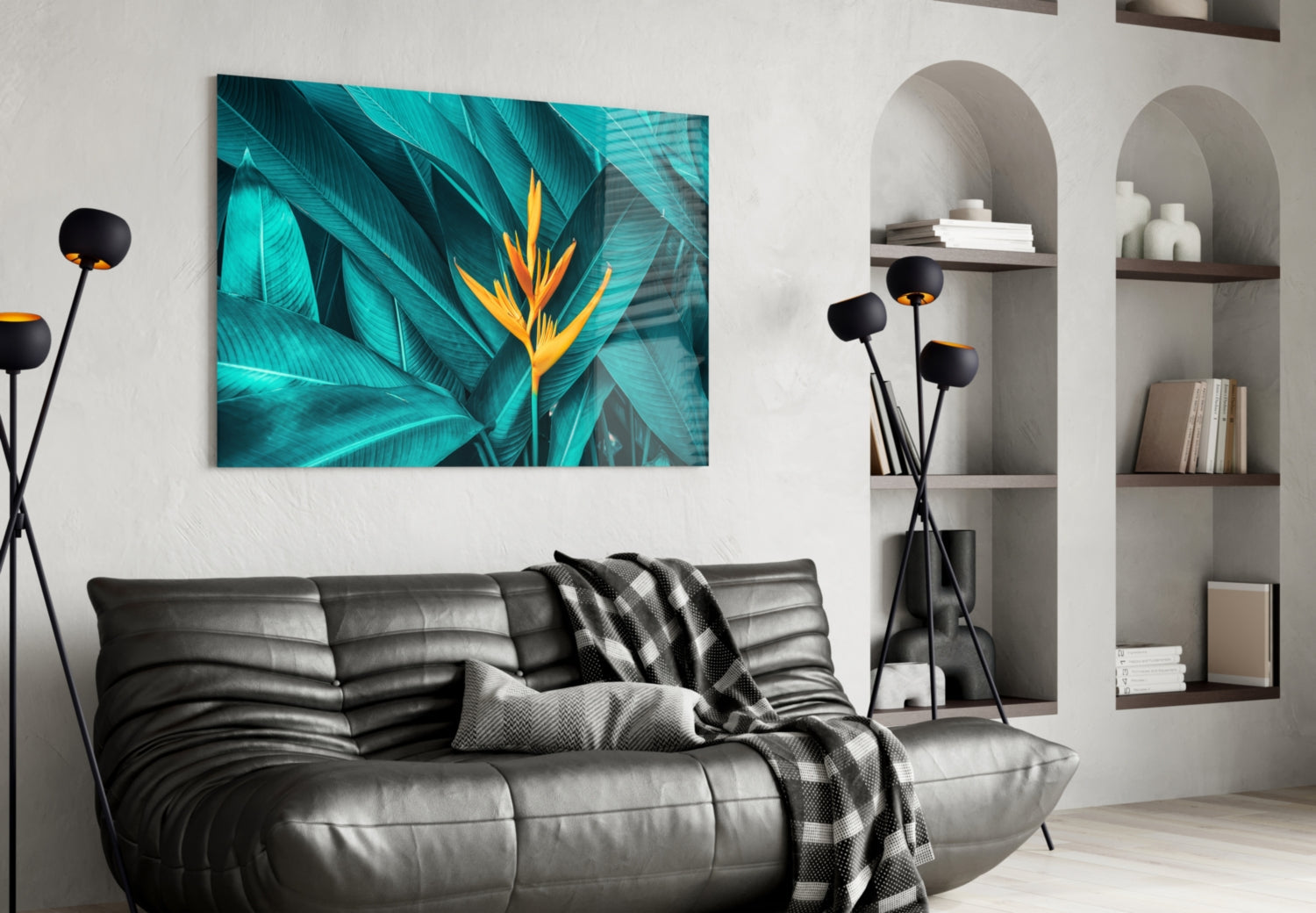 Tropical Leaf 3 glass wall art displaying turquoise foliage with yellow-orange bird of paradise flower mounted above black leather sofa.