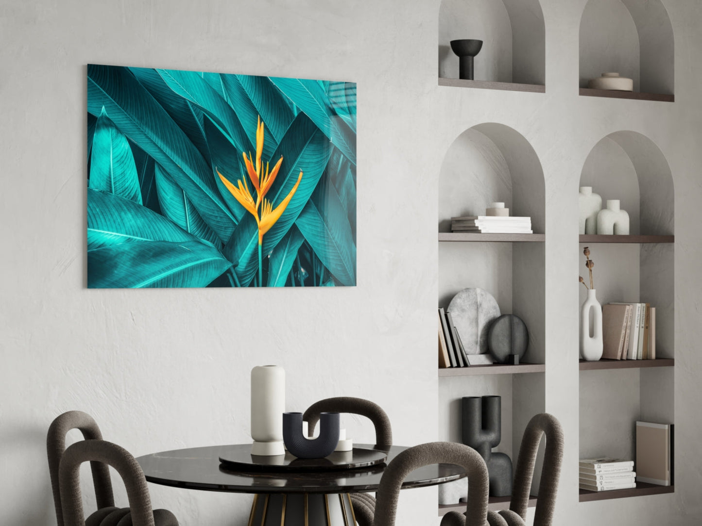 Vibrant tropical glass wall art featuring turquoise leaves and orange flower displayed above a black dining table.