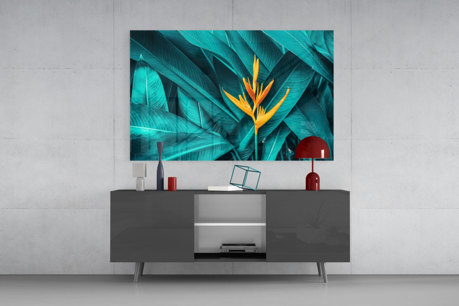 Tropical Leaf glass wall art featuring turquoise foliage and golden bird-of-paradise flower displayed above gray media console in modern interior setting.