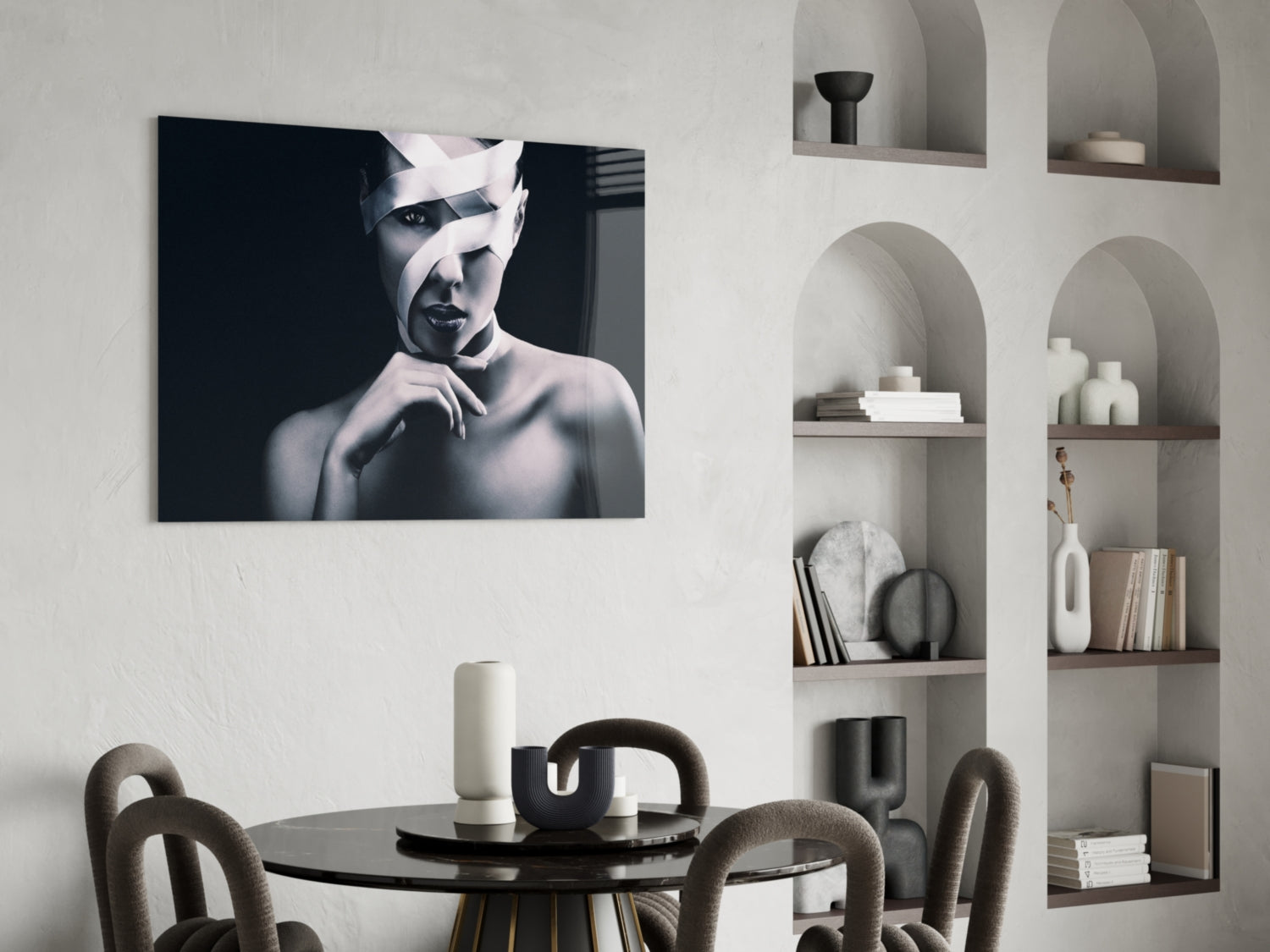 Black and white portrait of a woman with white bandages wrapped around her head, displayed as a glass wall art above a dining table.