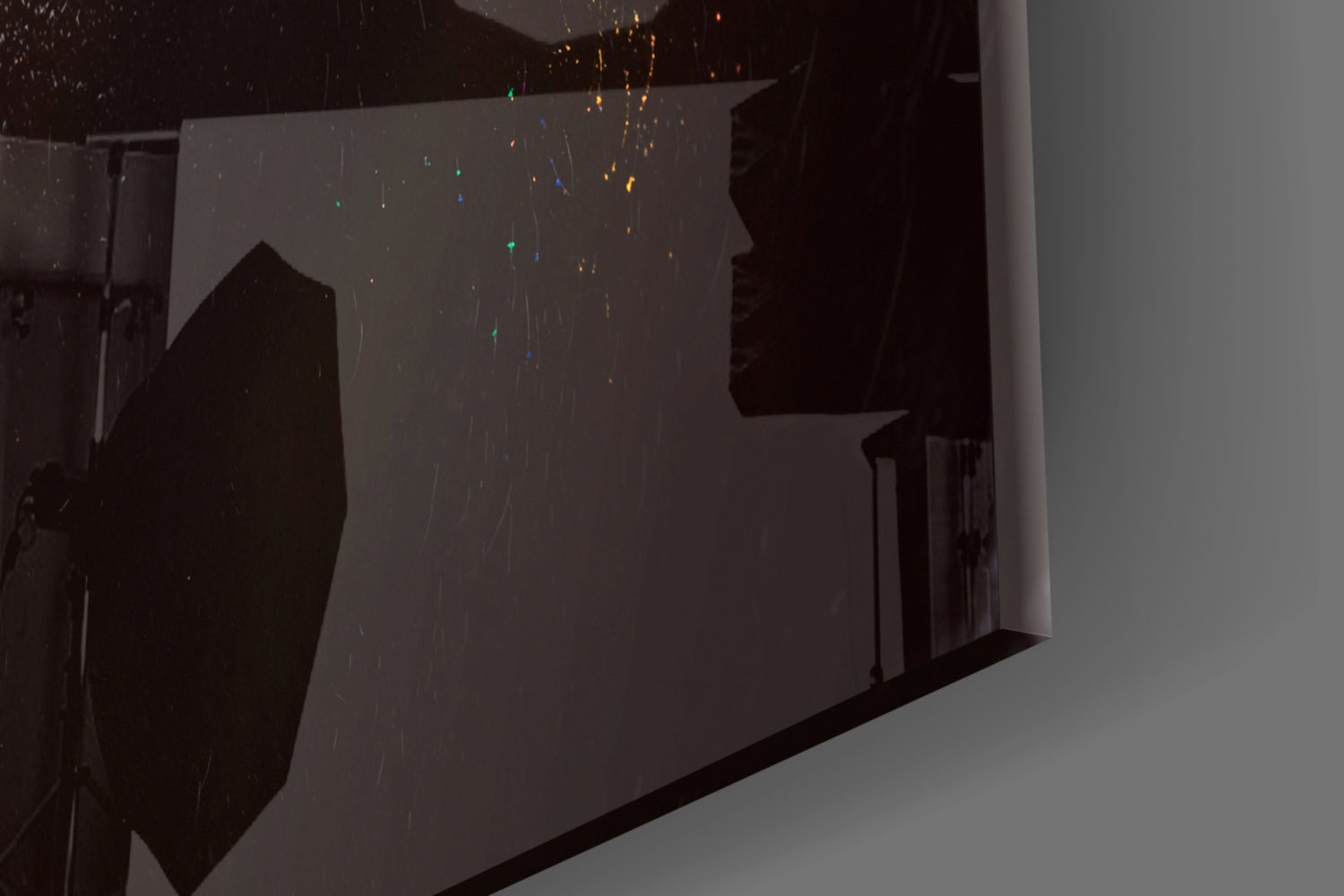 Silhouette of female portrait etched on frosted glass wall art panel with colorful hanging decorative elements above.
