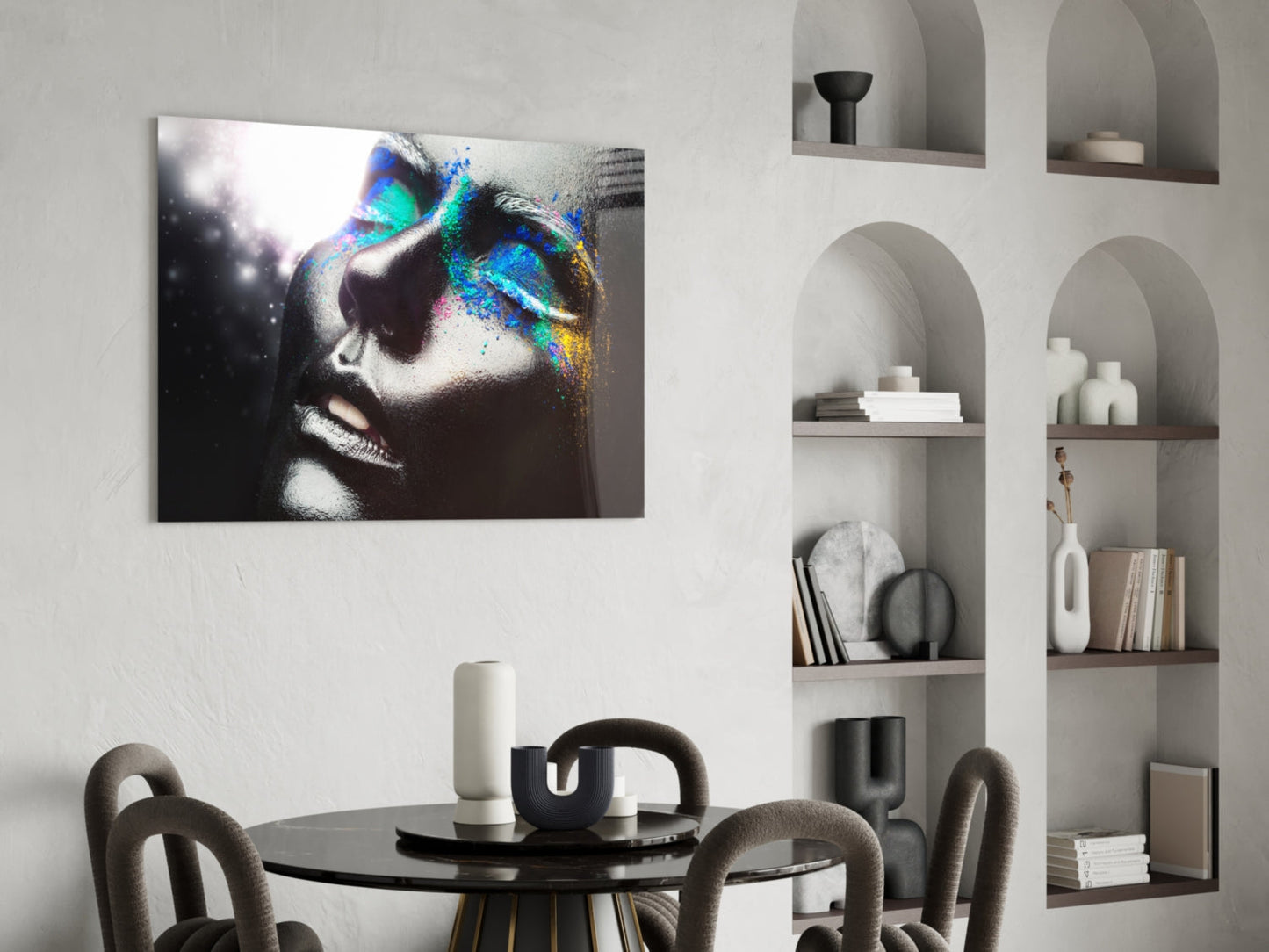 Glass wall art featuring a monochrome female portrait with vibrant blue and rainbow paint splatter effect displayed above a dining table.
