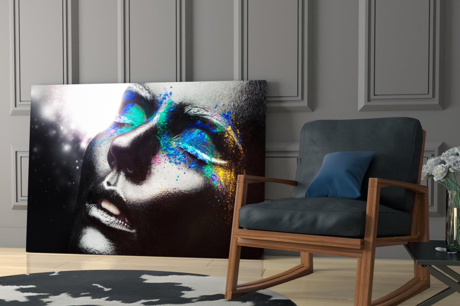 Modern interior showing colorful glass wall art with female portrait featuring vibrant blue, cyan, and gold paint splatter effects against black and white profile.