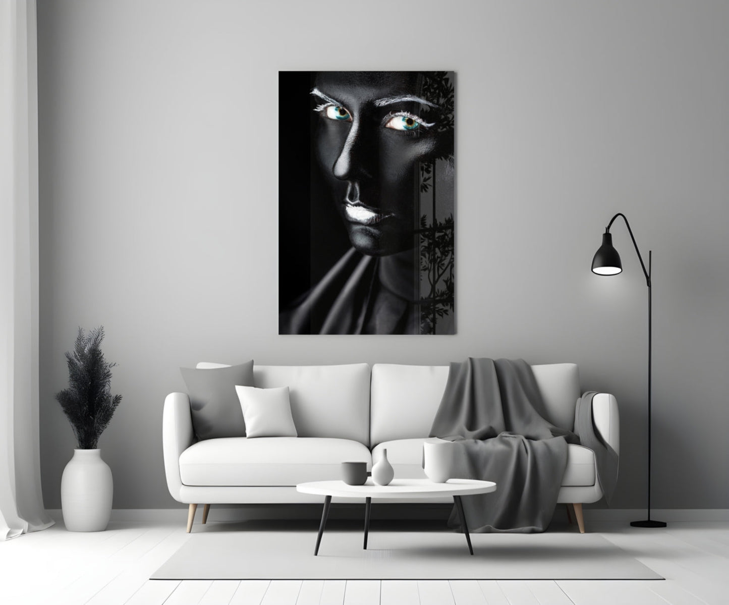 Black and white glass portrait of a woman with glowing eyes displayed above a white sofa in a modern living room.