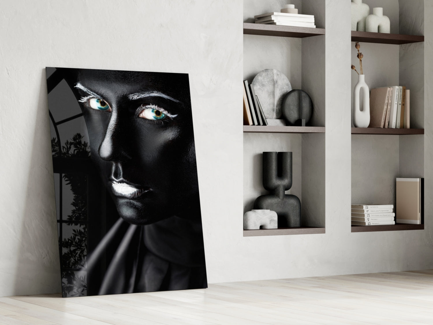Black and white glass portrait with striking turquoise eyes leaning against white wall beside shelving unit.