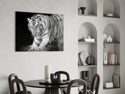 Black and white Bengal tiger glass wall art displayed above a round dining table with curved chairs in a minimalist interior.