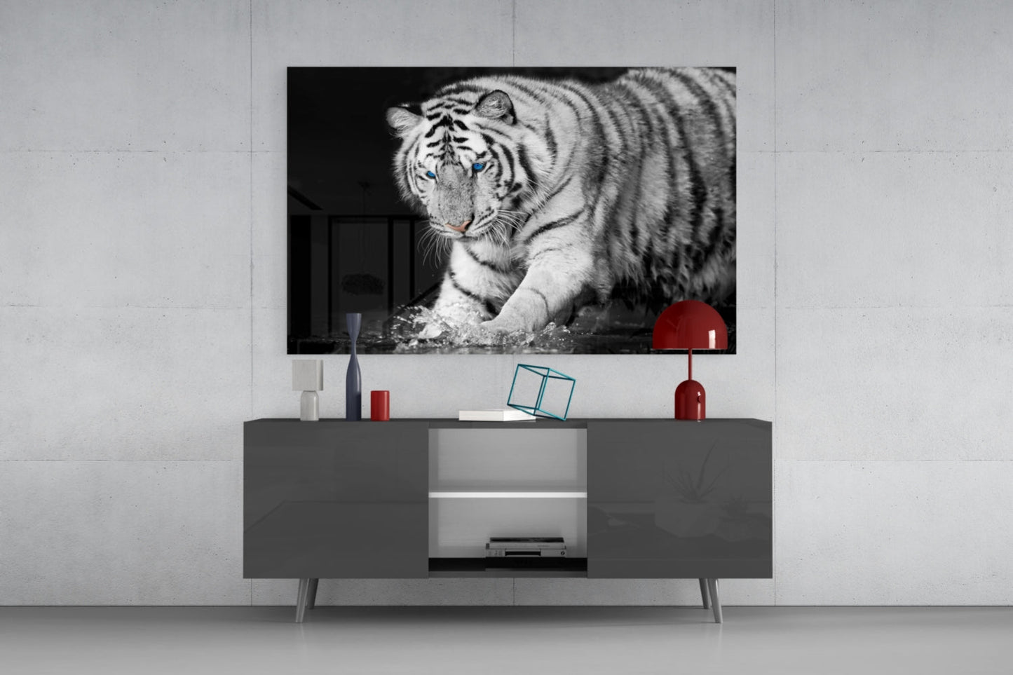Black and white Bengal tiger glass wall art displayed above gray media console with red decorative accents in modern interior setting.