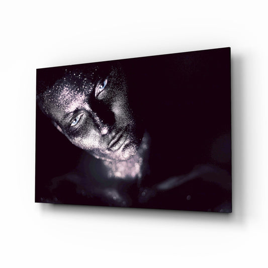 Glass wall art displaying a woman's face in profile covered with silver glitter against a dark background, shown at an angle.