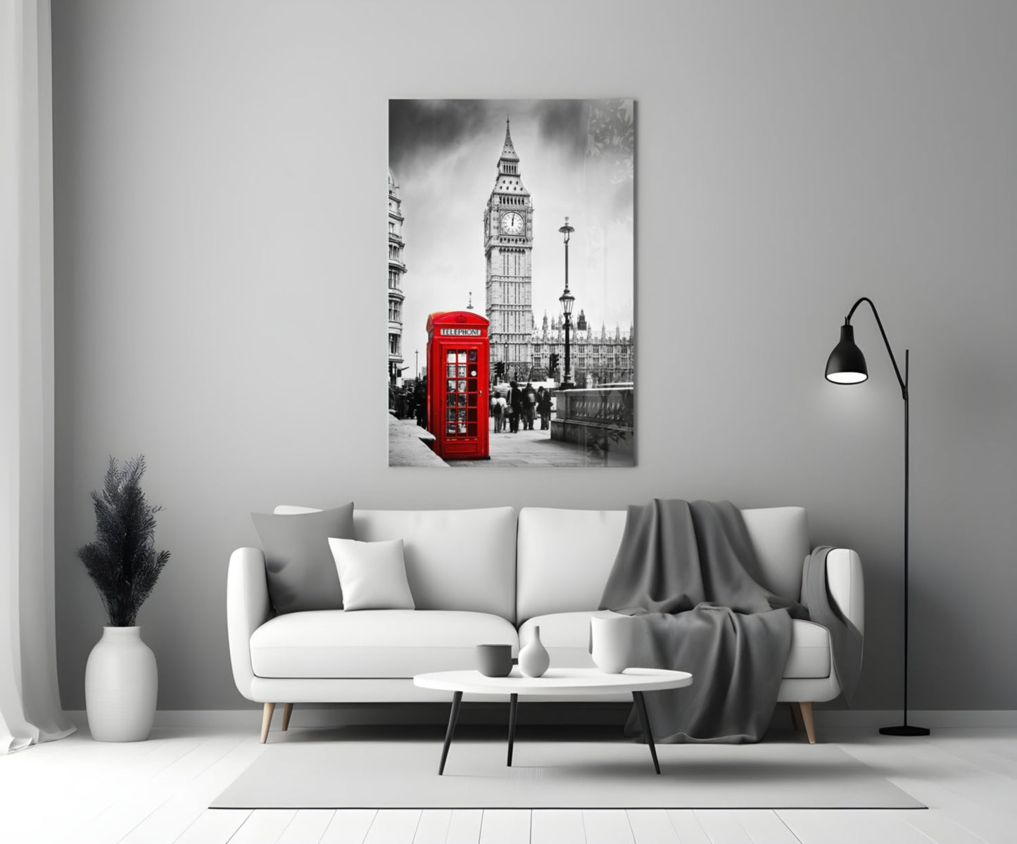 Black and white London street scene with iconic red telephone box and Big Ben displayed on glass wall art above white sofa.