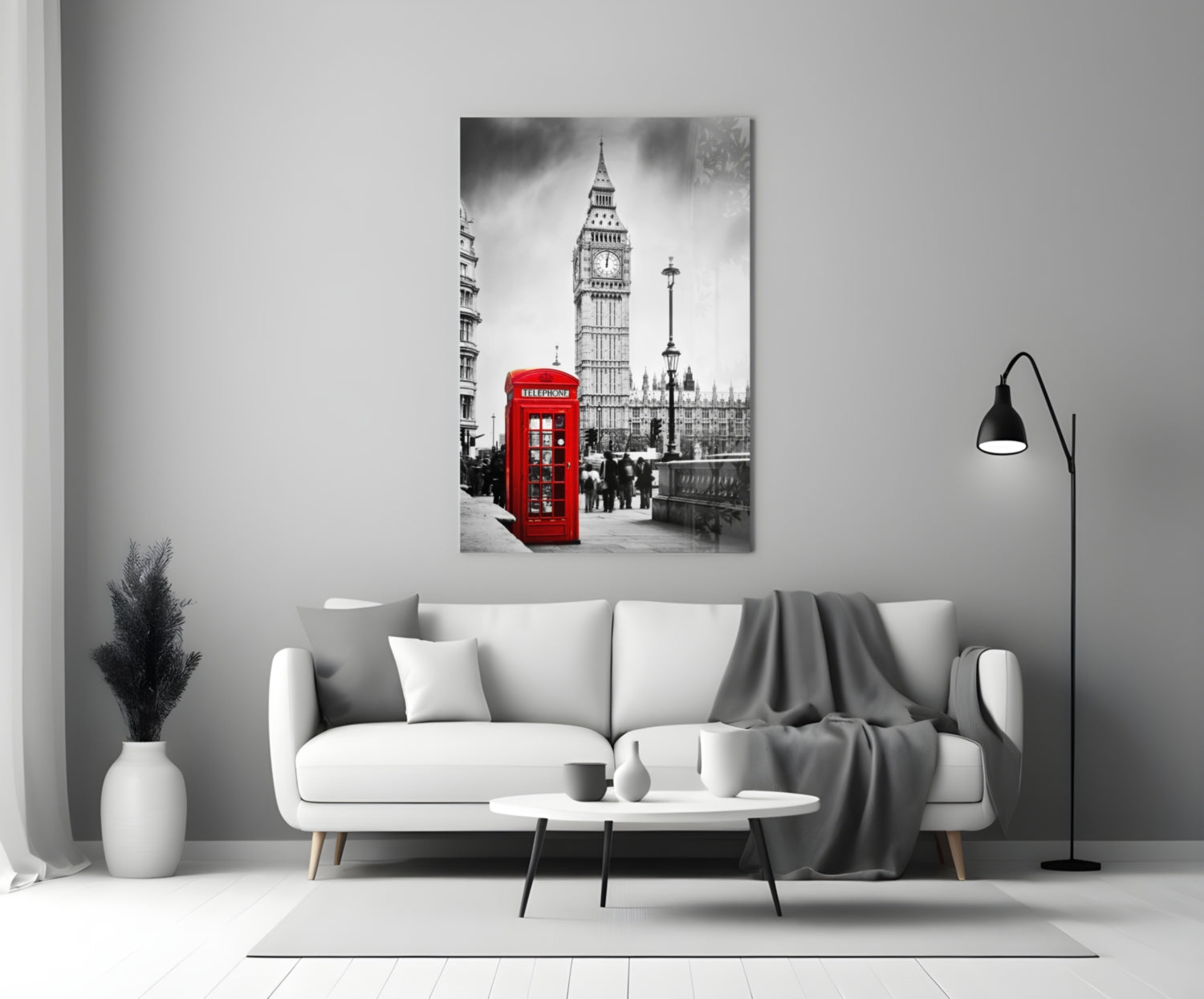 Black and white London street scene with iconic red telephone box and Big Ben displayed on glass wall art above white sofa.