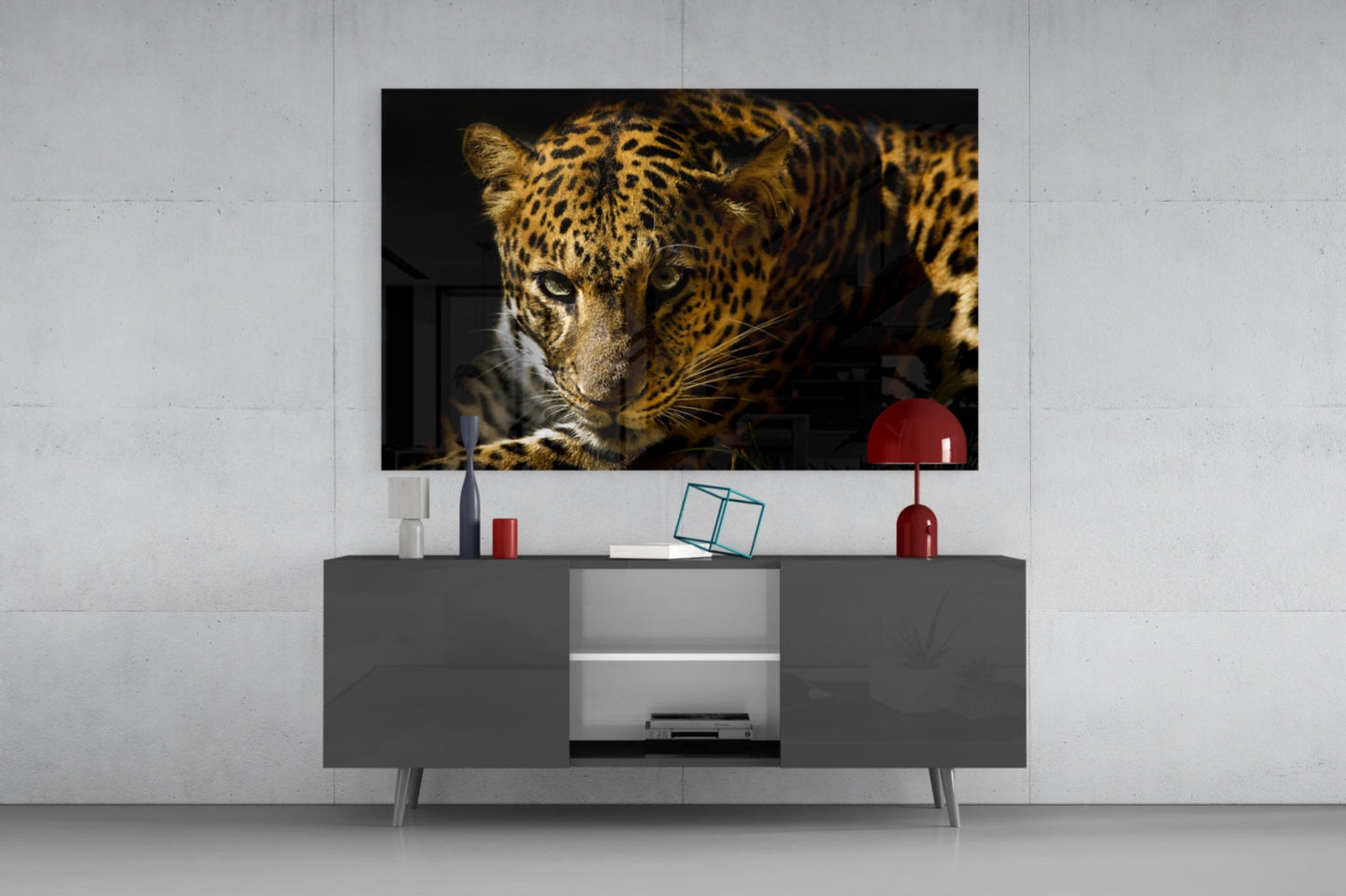 Leopard glass wall art displaying close-up of spotted big cat's face mounted above gray media console in modern interior setting.