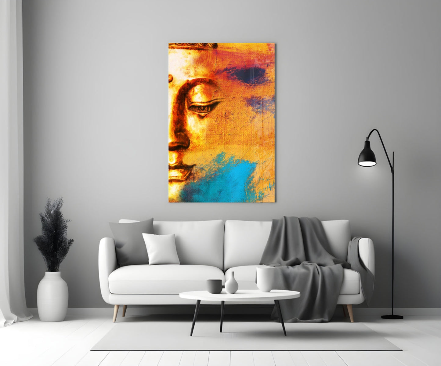 Buddha Portrait Glass Wall Art in warm gold and cool blue tones displayed above a white sofa in a minimalist living room.