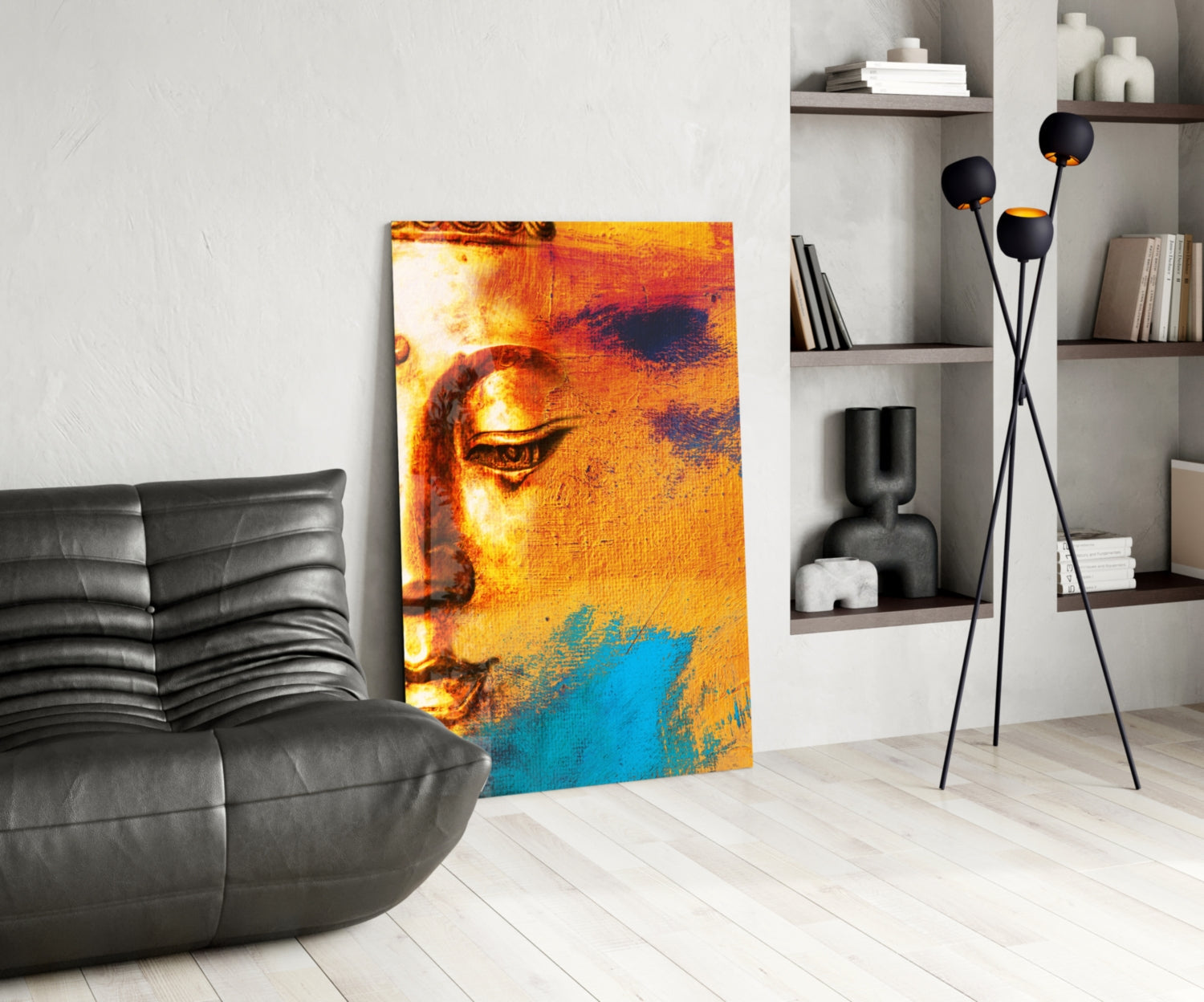 Buddha Portrait Glass Wall Art displaying golden and blue tones displayed in modern living room with black furniture and shelving.