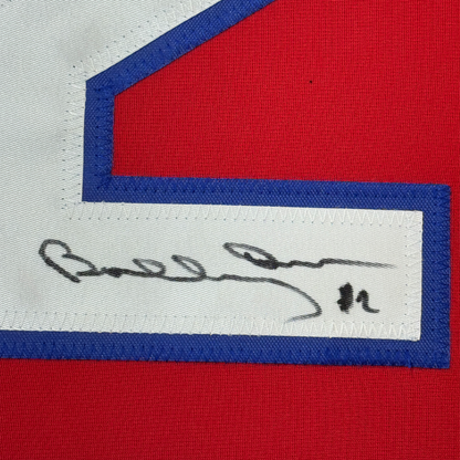 Close-up of handwritten signature on white stripe of red, white, and blue hockey jersey.