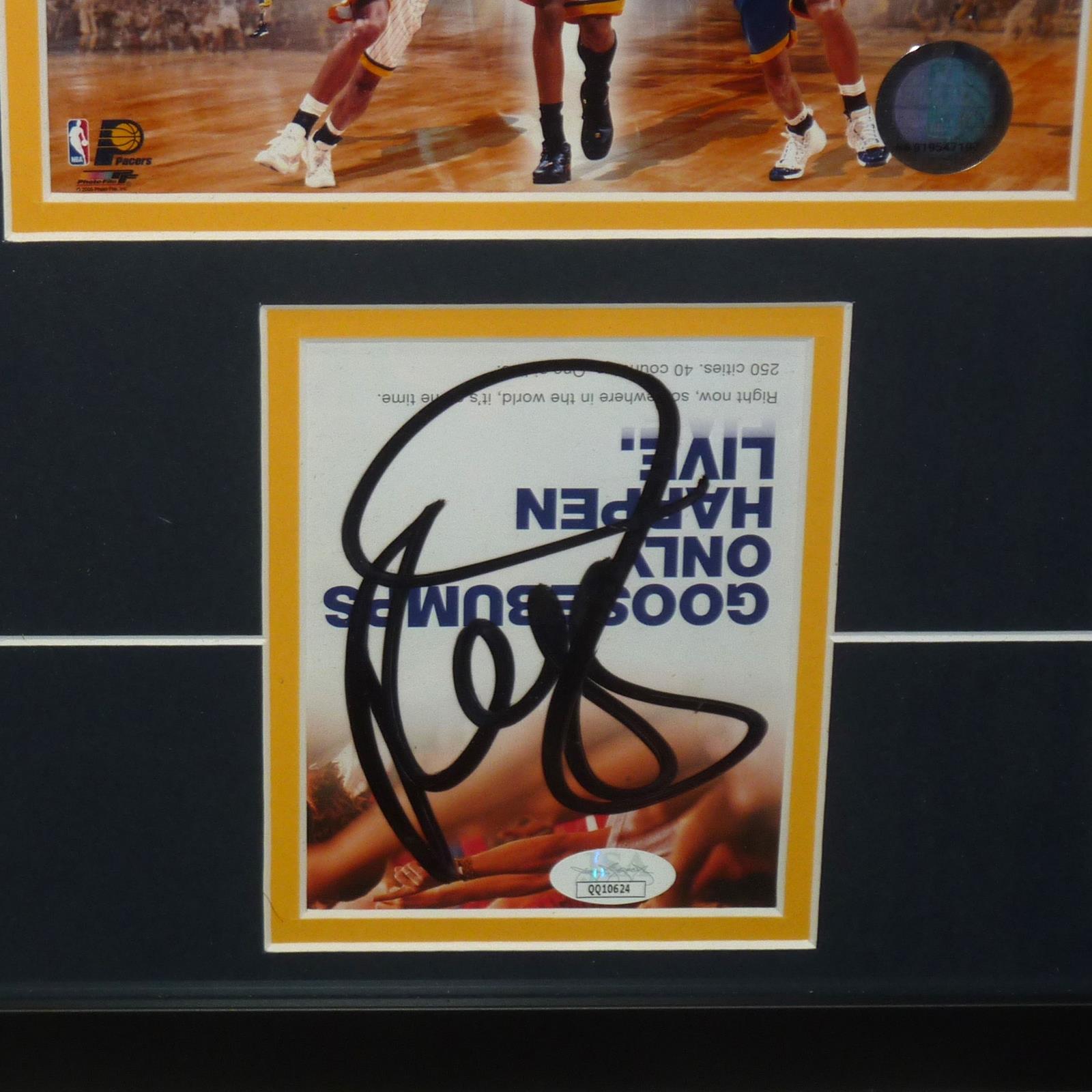 Close-up of autographed Indiana Pacers book cover with black marker signature and JSA authentication sticker on gold and white matting.