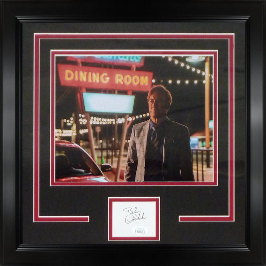 Framed photograph showing man in suit standing outside neon-lit "Dining Room" storefront at night, with autographed signature plate below.