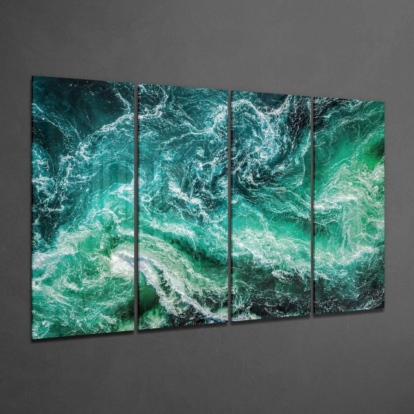 Four black-framed glass panels displaying aerial ocean waves in turquoise and white, mounted on gray wall.