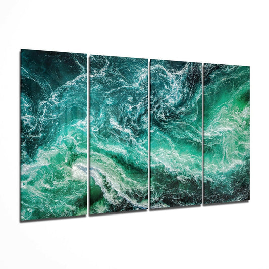 Aerial view of turquoise ocean waves with white foam creating patterns across deep green water.