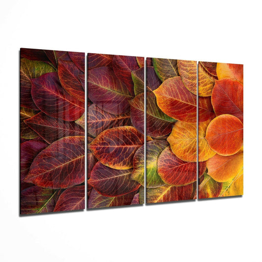 Four-panel glass wall art displaying close-up autumn leaves in red, orange, yellow, and burgundy tones with visible veins.