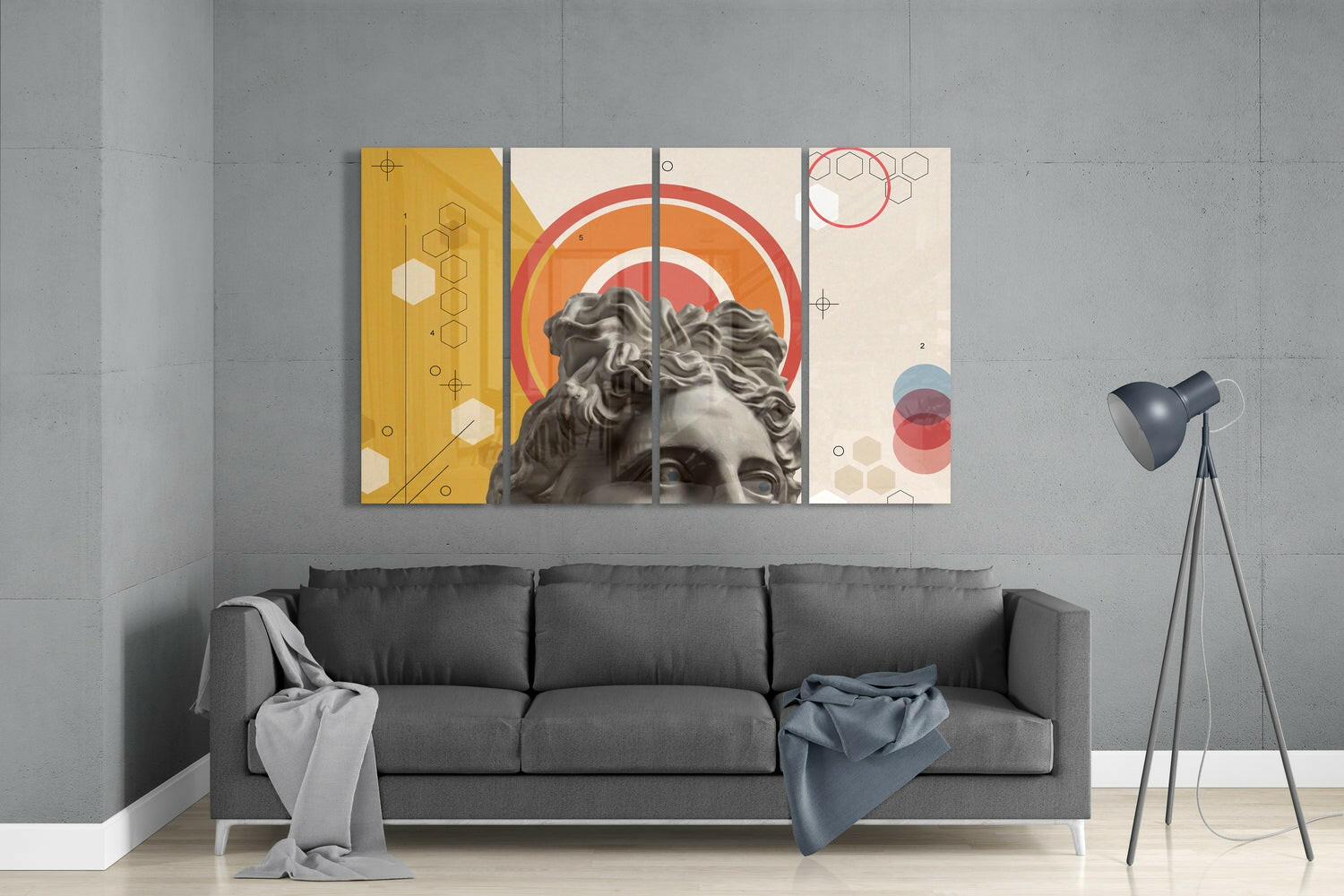 Modern living room interior with gray sofa displaying four-panel glass wall art featuring classical bust sculpture, geometric shapes, and warm color palette above.