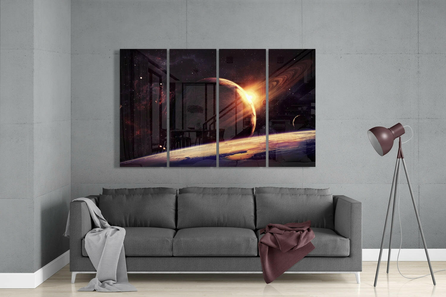 Four-panel glass wall art depicting a glowing planet and sun over Earth's horizon, displayed above a gray sofa in a modern living room.