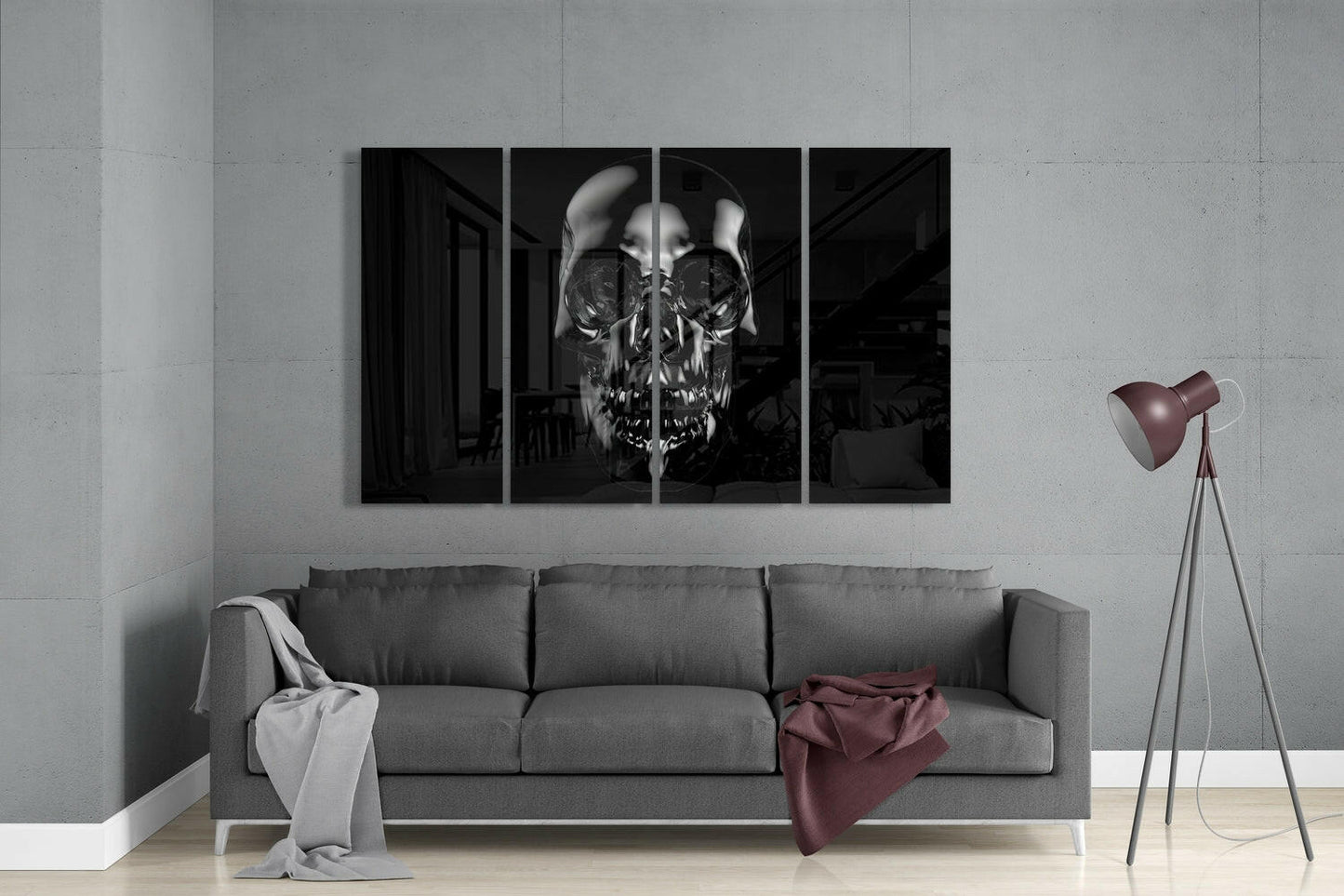 Four-panel black and white skull artwork displayed above gray sofa in modern living room with tripod lamp.
