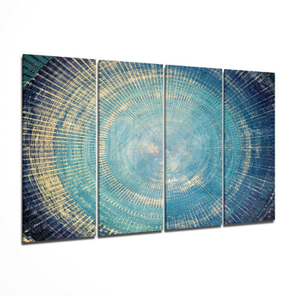 Four-panel glass wall art displaying a concentric circular pattern in turquoise, teal, and gold tones radiating from center.