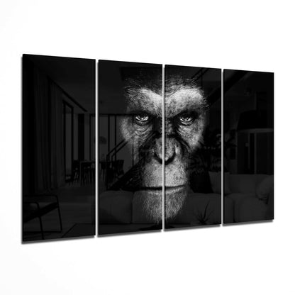 Four-panel black and white glass wall art displaying a close-up primate face with intense eyes against dark architectural interior background.