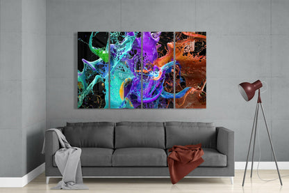 Colorful abstract glass wall art featuring vibrant swirls of cyan, purple, orange, and yellow displayed above gray sofa in modern living room.