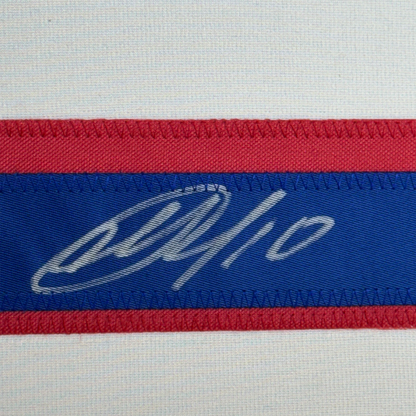 Close-up of striped ribbon featuring a handwritten signature on blue band between red stripes.