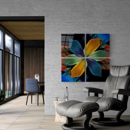 Colorful four-panel glass wall art displaying symmetrical flower petals in blue, yellow, green, and red mounted on white brick in modern living room.