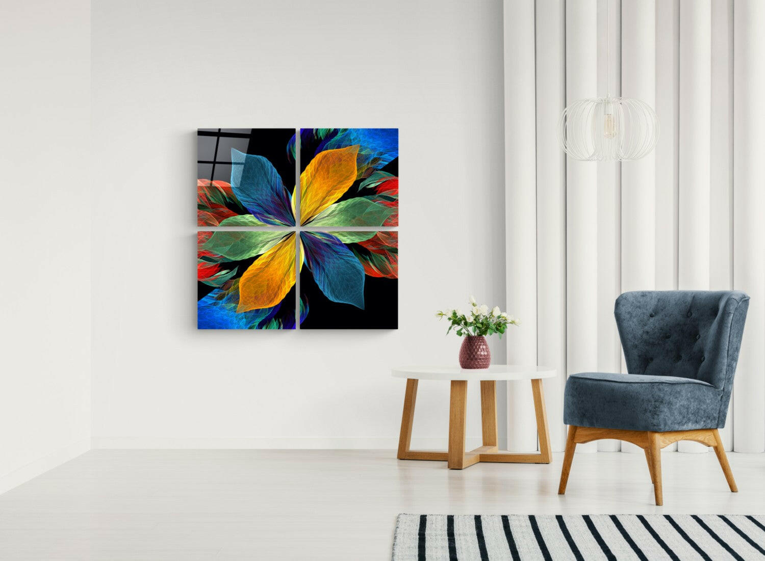 Colorful four-panel glass wall art depicting a radial flower design in blue, yellow, green, and red displayed above a side table in a minimalist interior.