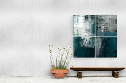 Four-panel green and white glass wall art displayed above wooden bench with potted yellow flowers against white wall.