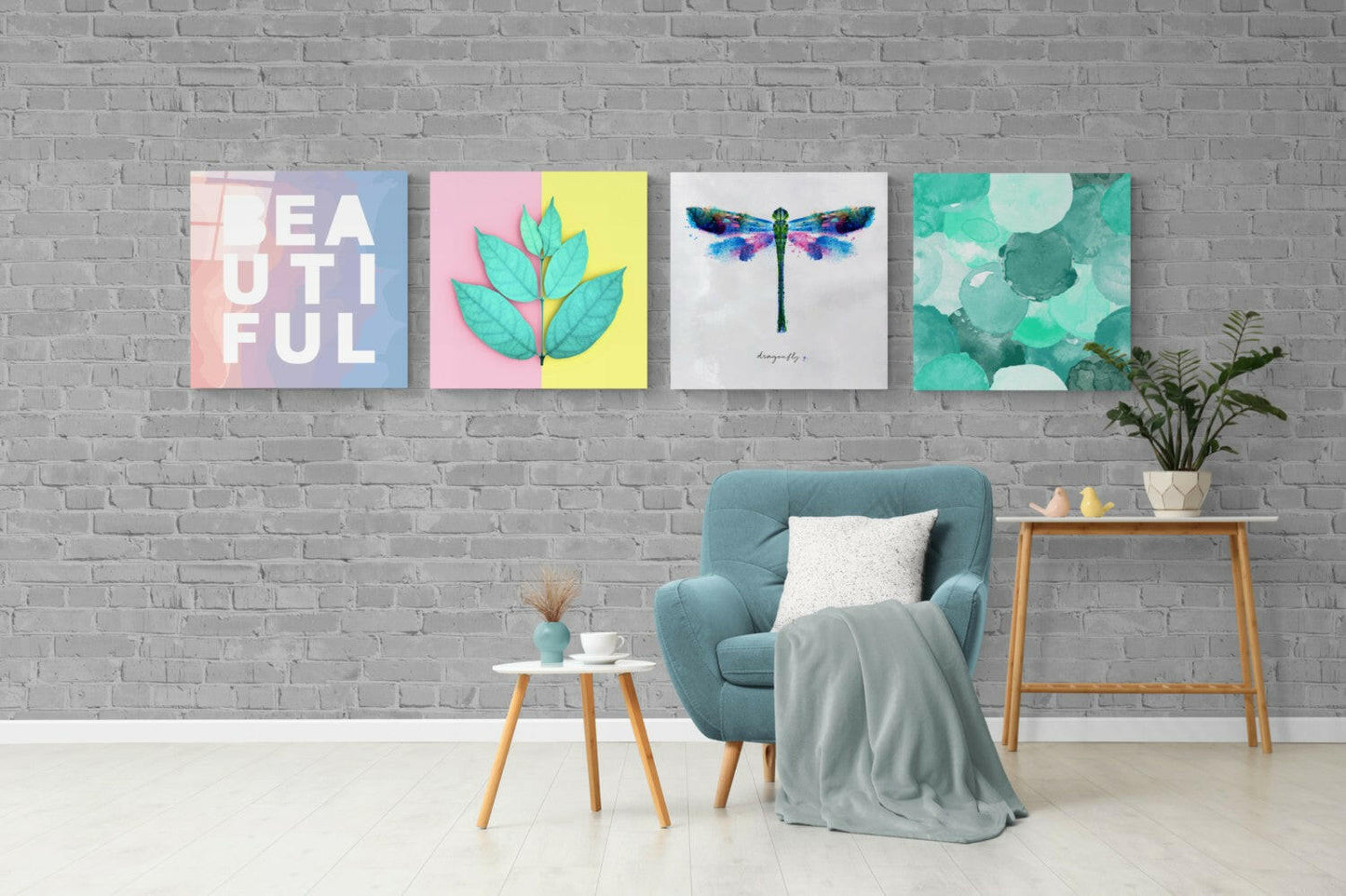 Four glass wall art panels in pastel colors displaying "beautiful," botanical leaves, watercolor dragonfly, and abstract circles hung above teal armchair in modern living room.