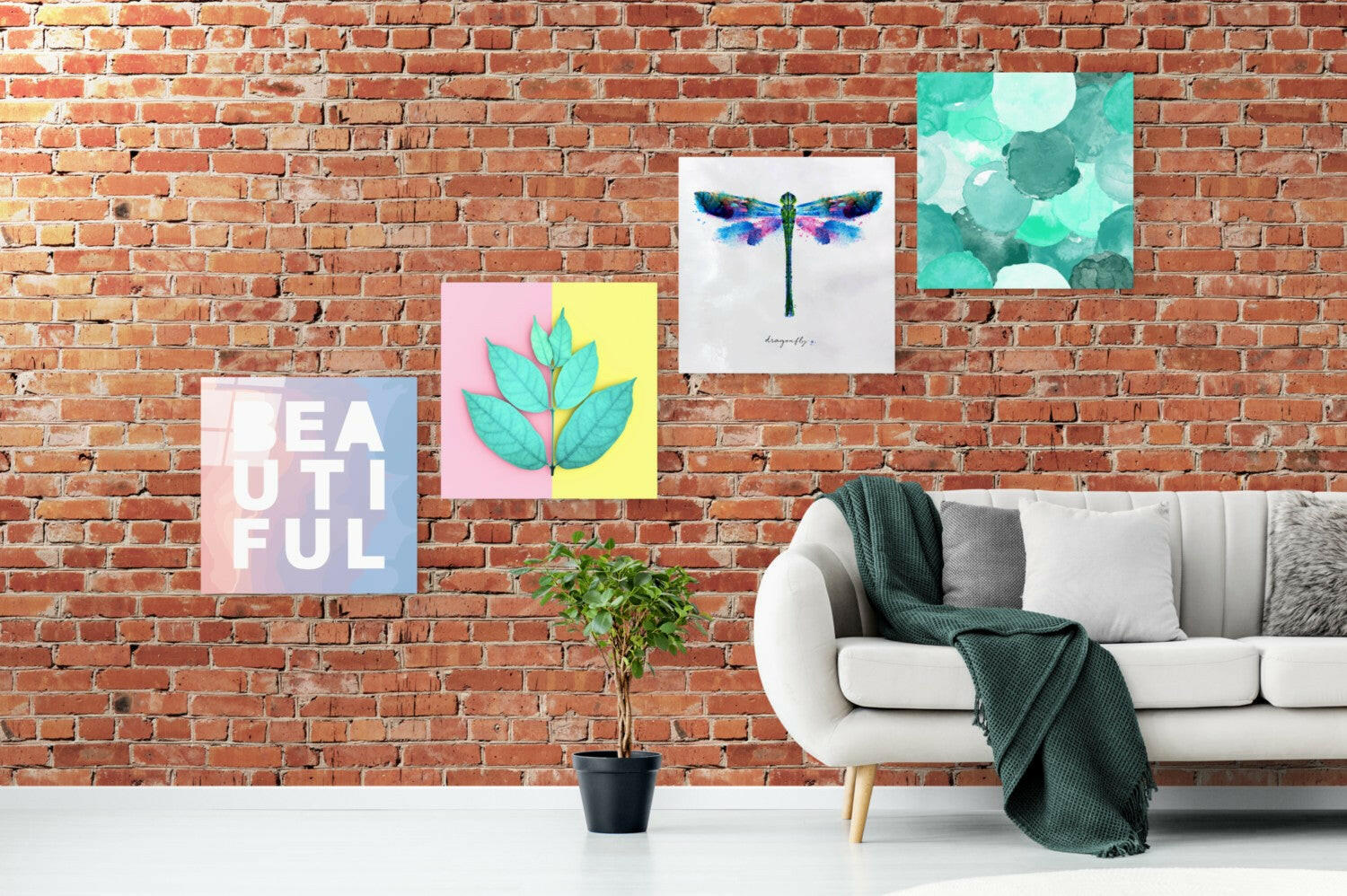 Room setting displaying four glass wall art panels on exposed brick: pink "Beautiful" text, split pink-yellow panel with turquoise leaves, watercolor dragonfly, and turquoise bubble pattern.
