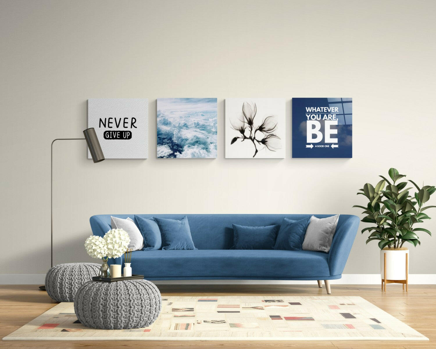Four motivational glass wall art panels above blue sofa displaying "Never Give Up," landscape, botanical, and "Whatever You Are Be" text.