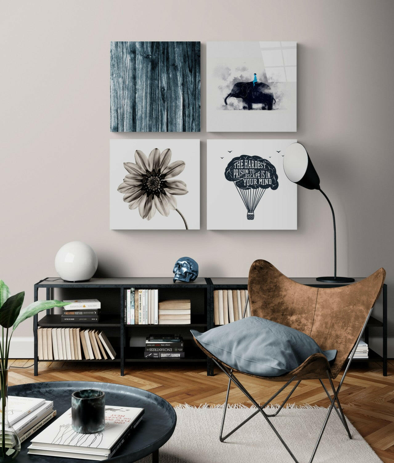 Four framed artworks displayed on a beige wall above a black shelving unit, including a wooden texture, elephant with figure, daisy flower, and hot air balloon with inspirational text.