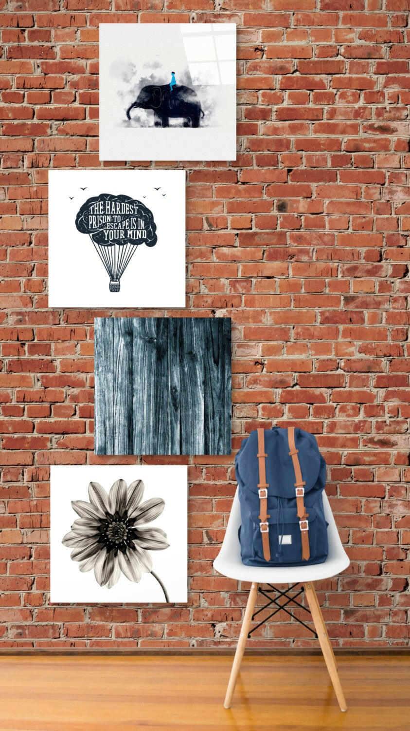 Four framed prints on brick wall above white chair: elephant with figure, hot air balloon with text, weathered wood texture, and flower illustration.