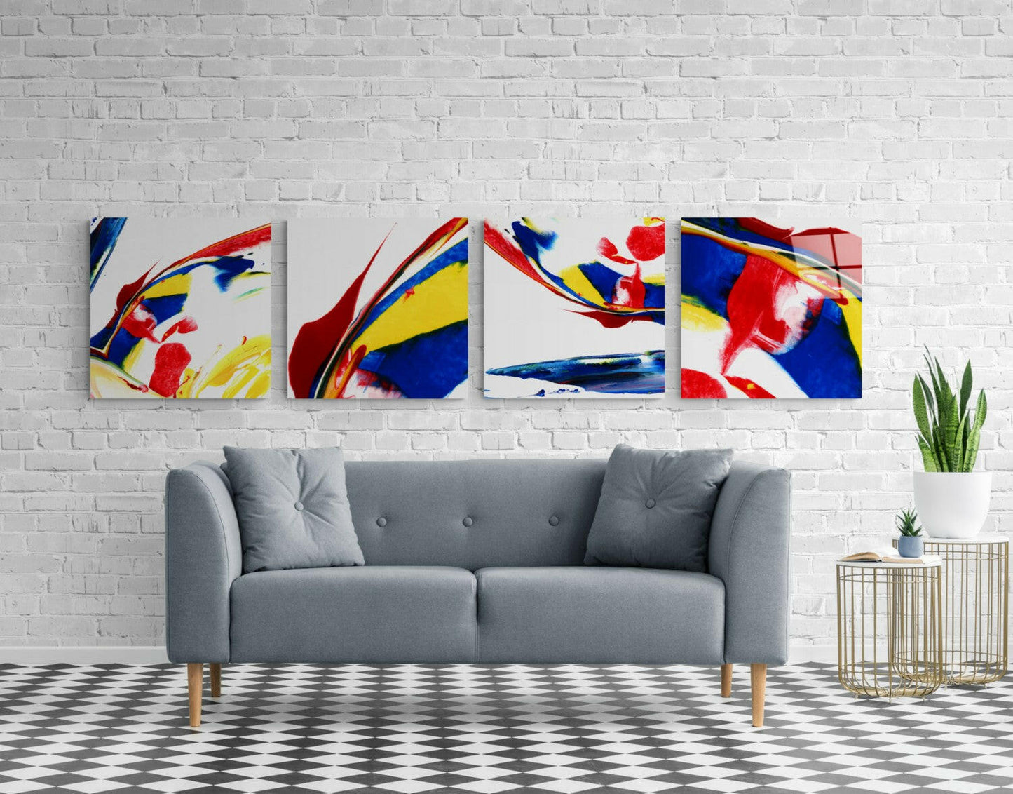 Gray sofa against white brick wall with four abstract glass art panels featuring red, blue, and yellow brushstrokes above.