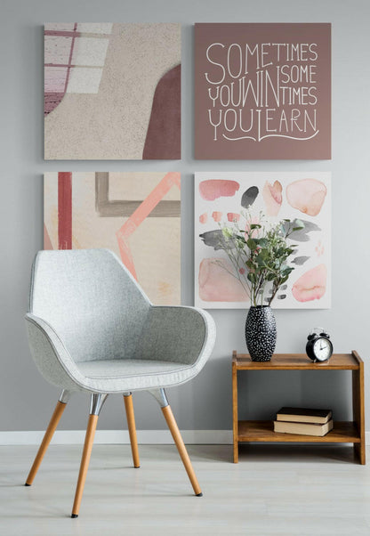 Modern interior scene with light gray mid-century chair beside wooden side table displaying black clock and vase with pink flowers, four framed wall artworks above including motivational text on mauve background.