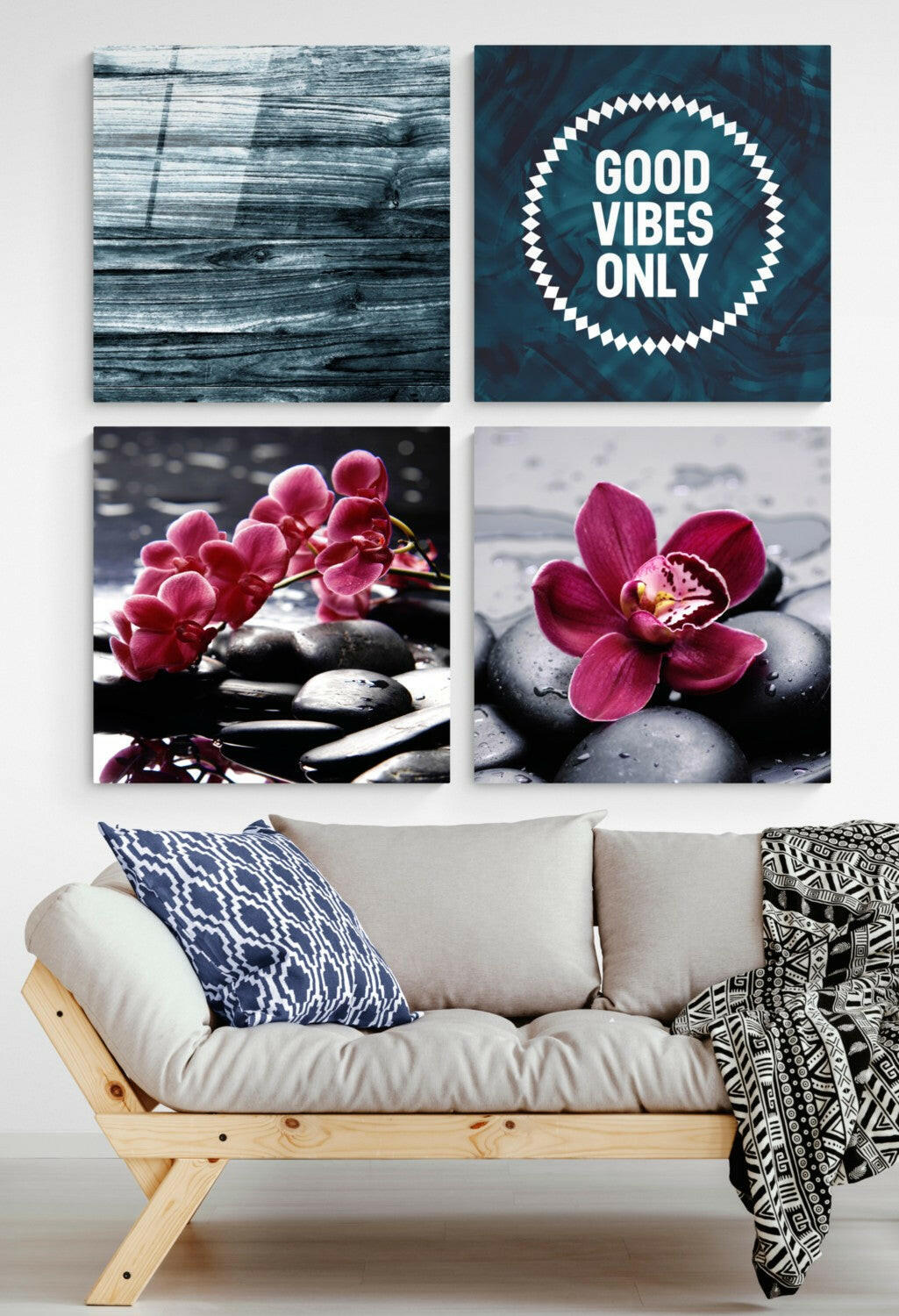 Four glass wall art panels displayed above a wooden sofa: weathered blue wood, "Good Vibes Only" text, and two pink orchids on black stones.