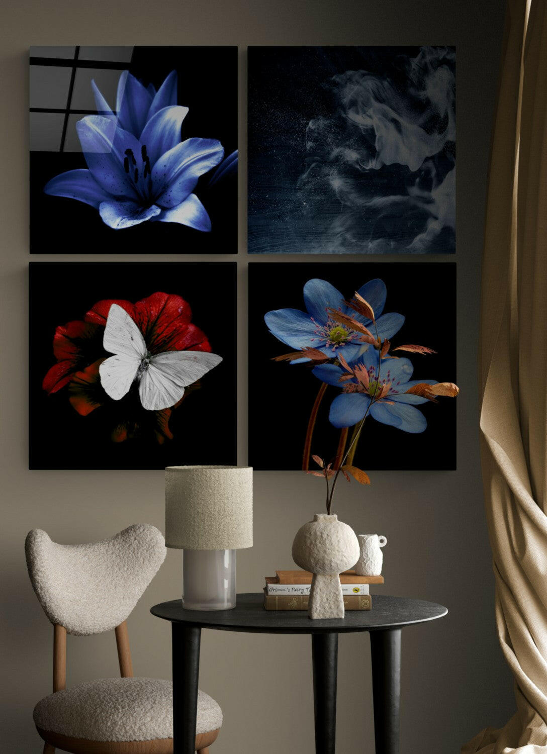 Four glass wall art panels featuring blue lilies, white butterfly on red flower, atmospheric clouds, and blue flowers with brown stems, displayed above a round black table with white textured chair and ceramic vase.