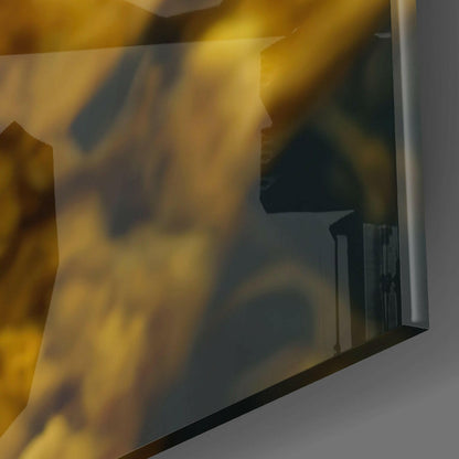 Close-up angled view of textured glass wall art showing golden and amber tones with dark shadowed areas and reflective surface.