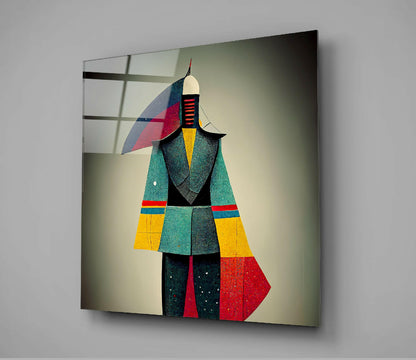 Colorful geometric glass wall art depicting an abstract figure in teal, yellow, red, and black segments mounted on a gray wall, angled perspective view.